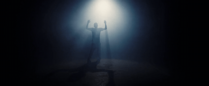 a person standing under a light in the dark