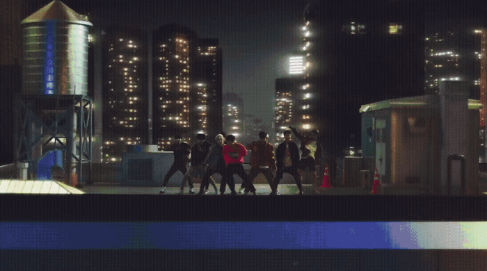 a group of people walking down a street at night