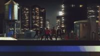 a group of people walking down a street at night