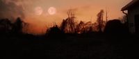 the sun is setting over a field with trees