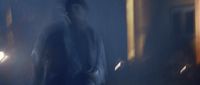 a blurry image of a man walking in a dark room