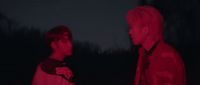 two men standing next to each other in the dark