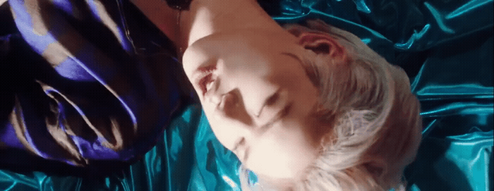 a woman laying on top of a blue sheet