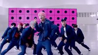 a group of young men dancing in front of a pink wall