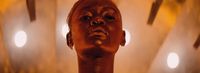 a close up of a person's head with lights in the background