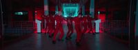 a group of people dressed in red dancing in a hallway