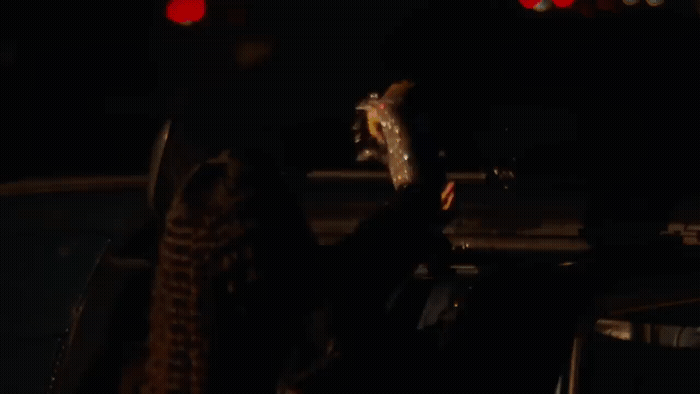 a person holding a skateboard in the dark