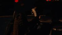 a person holding a skateboard in the dark