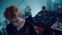 a woman with red hair standing in a kitchen