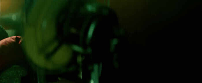 a man in a green shirt is looking at his cell phone