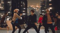a group of young men dancing in a city at night