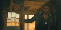 a man in a leather jacket standing in a doorway