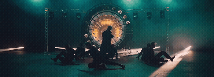 a group of people sitting on the ground in front of a stage