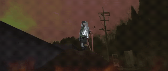 a man standing on top of a roof next to a fire