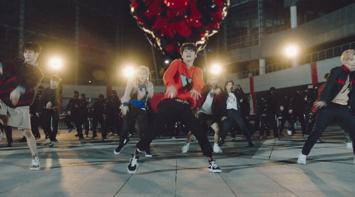 a group of young men and women dancing on a dance floor