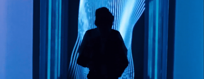 a man standing in front of a blue wall