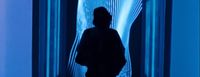 a man standing in front of a blue wall