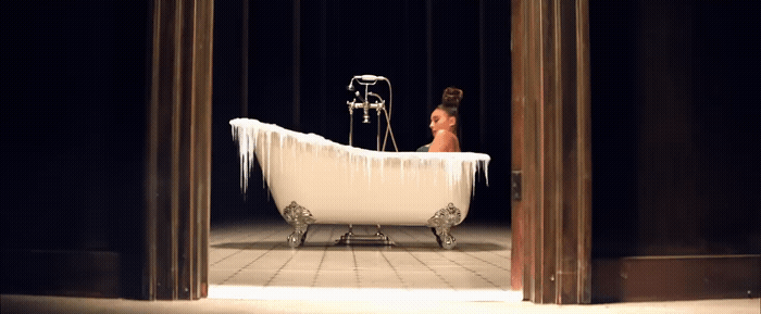 a woman sitting in a bathtub with icicles on it