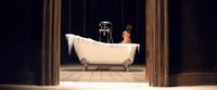 a woman sitting in a bathtub with icicles on it