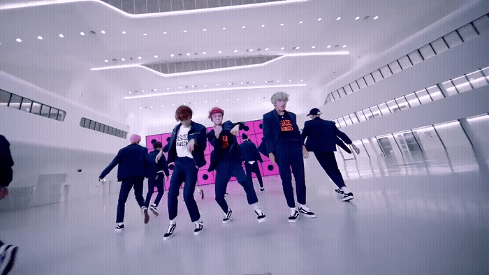 a group of young men dancing in a large room