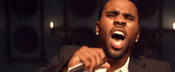 a man in a suit is singing into a microphone