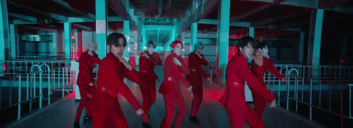 a group of people in red outfits dancing on a stage