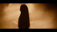 a woman with long hair standing in front of smoke