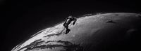 a black and white photo of a person on a surfboard