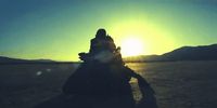 a person riding a motorcycle in the middle of a desert
