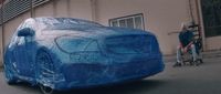 a car covered in plastic sitting on the side of a road