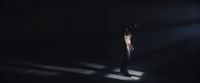a man standing in the dark with his hands on his hips