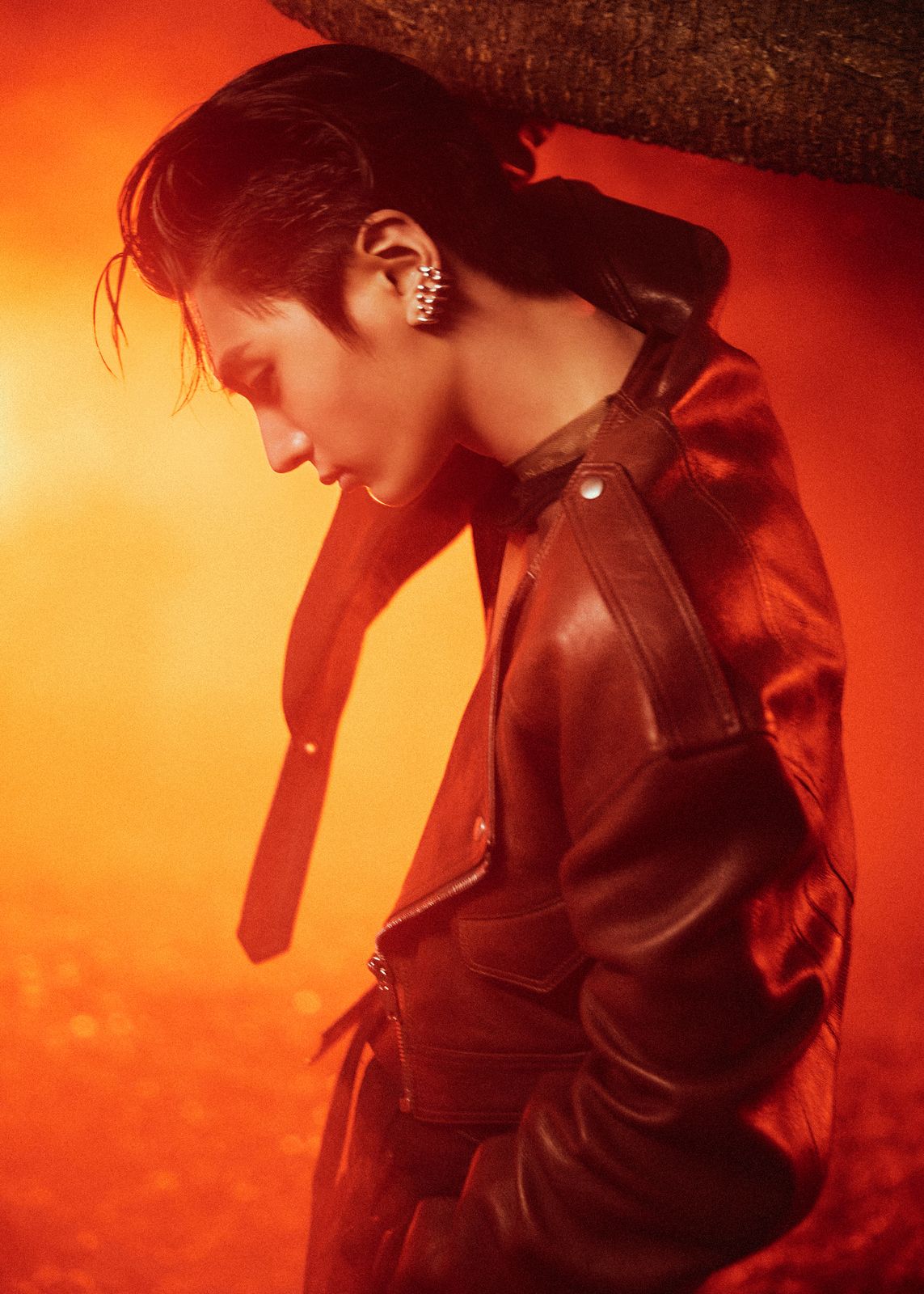 a woman wearing a leather jacket and ear piercings