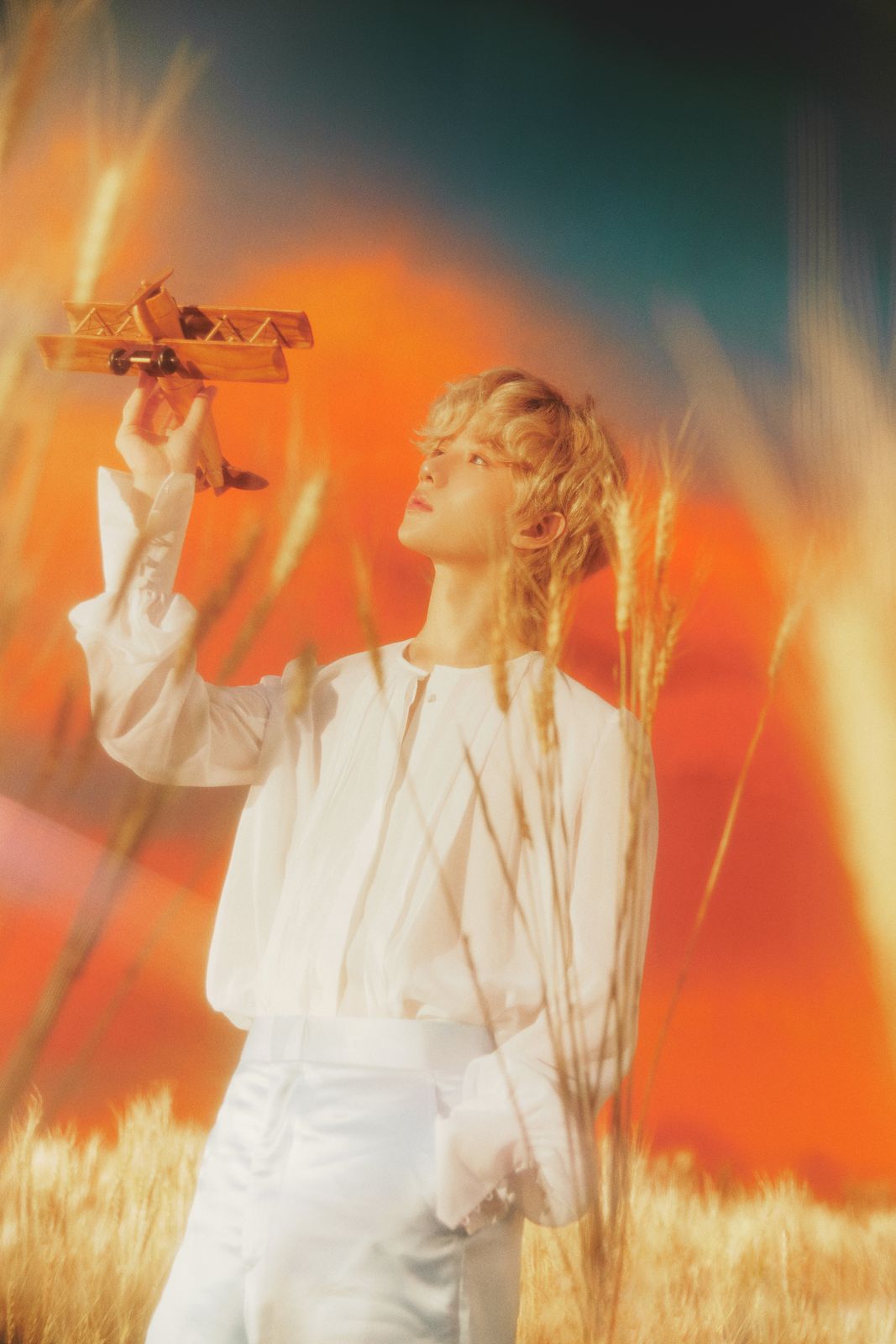 a woman standing in a field holding a toy airplane