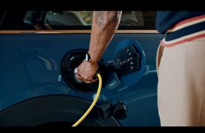 a man pumping gas into a blue car