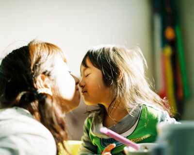 a little girl kissing a little girl with a toothbrush