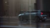 a car driving down a street next to tall buildings