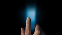 a person's hand holding a cell phone in the dark