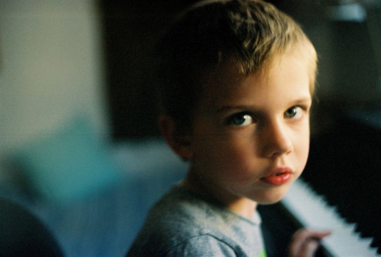 a young boy playing a piano in a living room