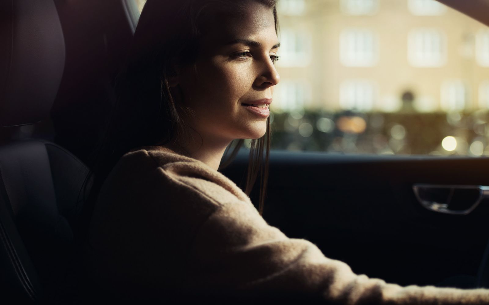 a woman sitting in a car looking out the window