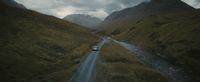 a car driving down a road in the mountains