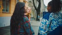 a group of women standing next to each other on a sidewalk