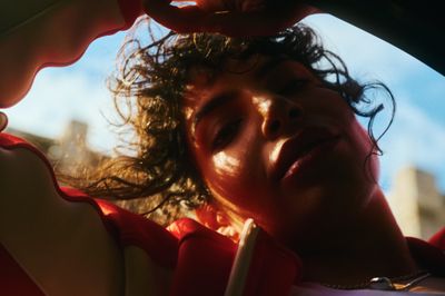 a woman with curly hair is sitting in a car