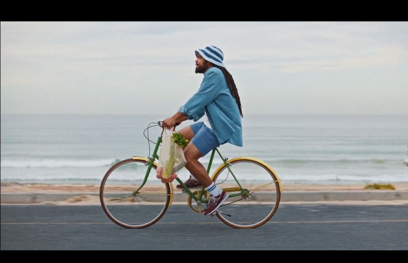 a man riding a bike down a street next to the ocean