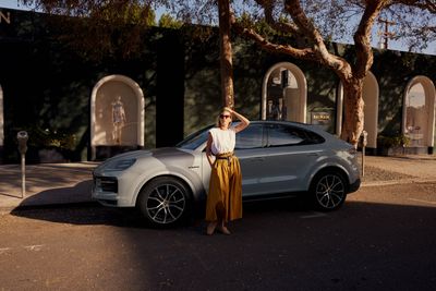 a woman standing next to a silver car