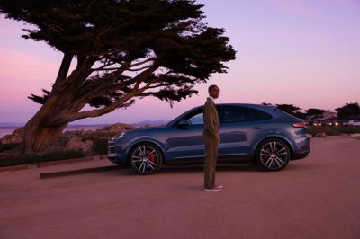 a blue car parked next to a tall wooden pole