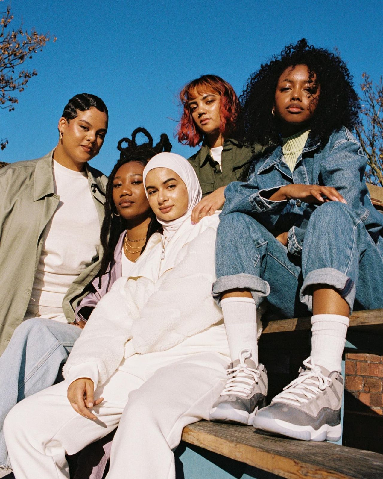 a group of women sitting on top of a wooden bench