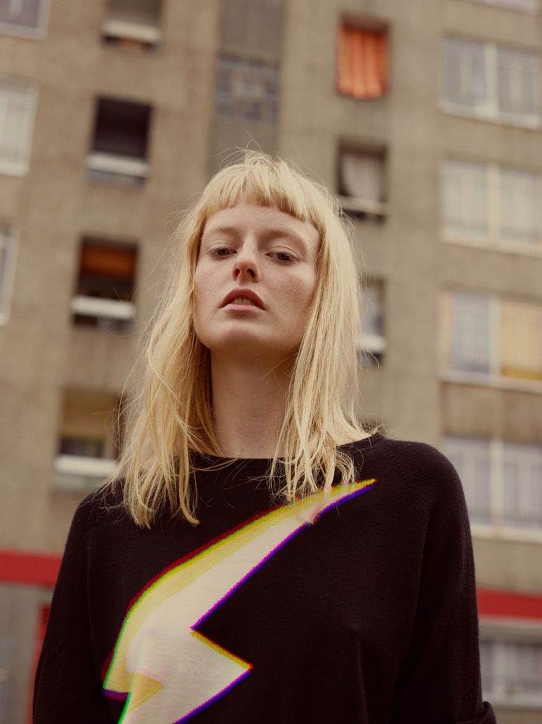 a woman standing in front of a tall building