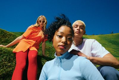 a group of people sitting on top of a lush green hillside