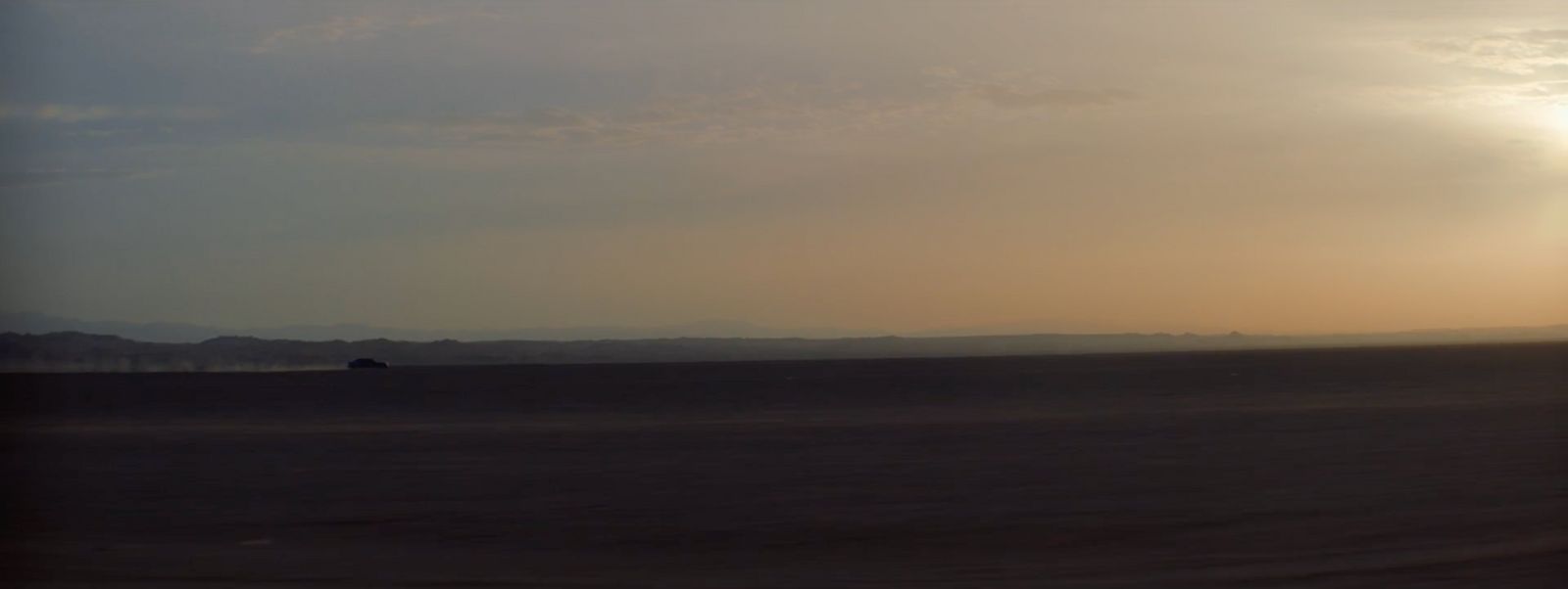 the sun is setting over the horizon of the desert