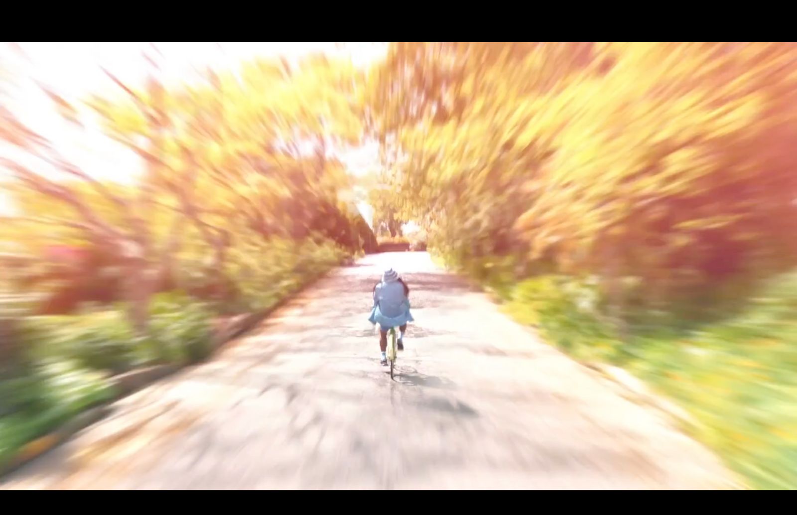 a blurry photo of a person riding a bike down a road